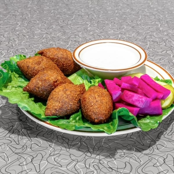 Le Kabob's kibbeh platter with five fried kibbeh, white sauce, and bright pink pickled turnips.